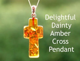 A hand-shaped amber cross pendant on a silver chain, with text describing the amber as 'Delightful Dainty Amber' and the pendant as 'Cross Pendant'.