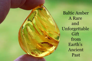 Teardrop-shaped Baltic Amber held between fingers with text on a blurred green background