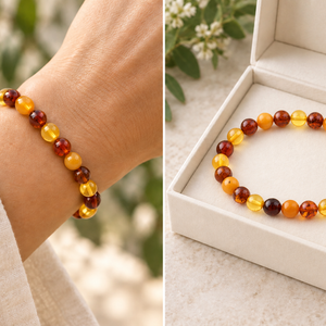 A split image showing a beaded bracelet worn on a wrist on the left, and the same bracelet displayed inside an open cream-colored jewelry box on the right. The bracelet consists of polished amber-yellow and dark reddish-brown translucent beads.