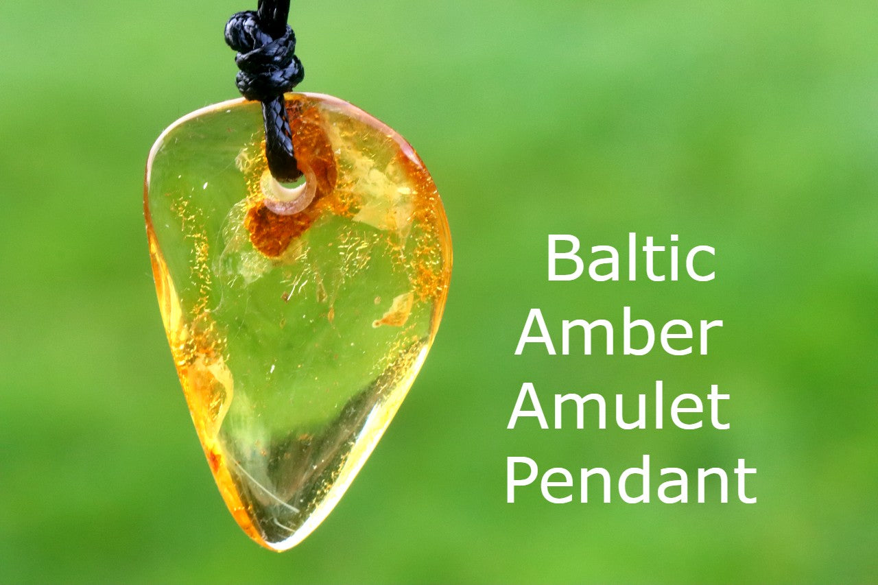 Baltic Amber Amulet Pendant on a blurred green background