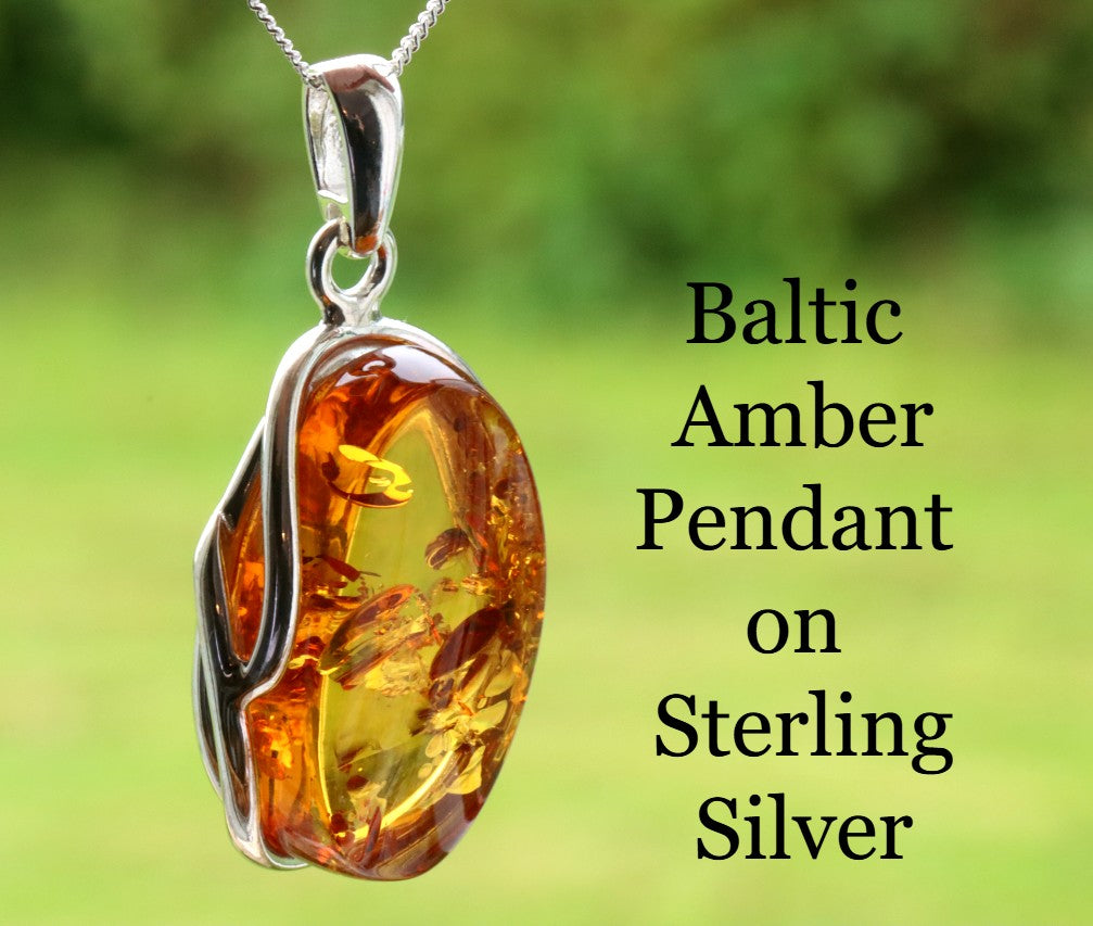 Baltic Amber Pendant on Sterling Silver with a blurred green background