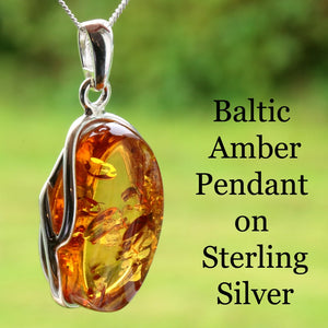 Baltic Amber Pendant on Sterling Silver with a blurred green background