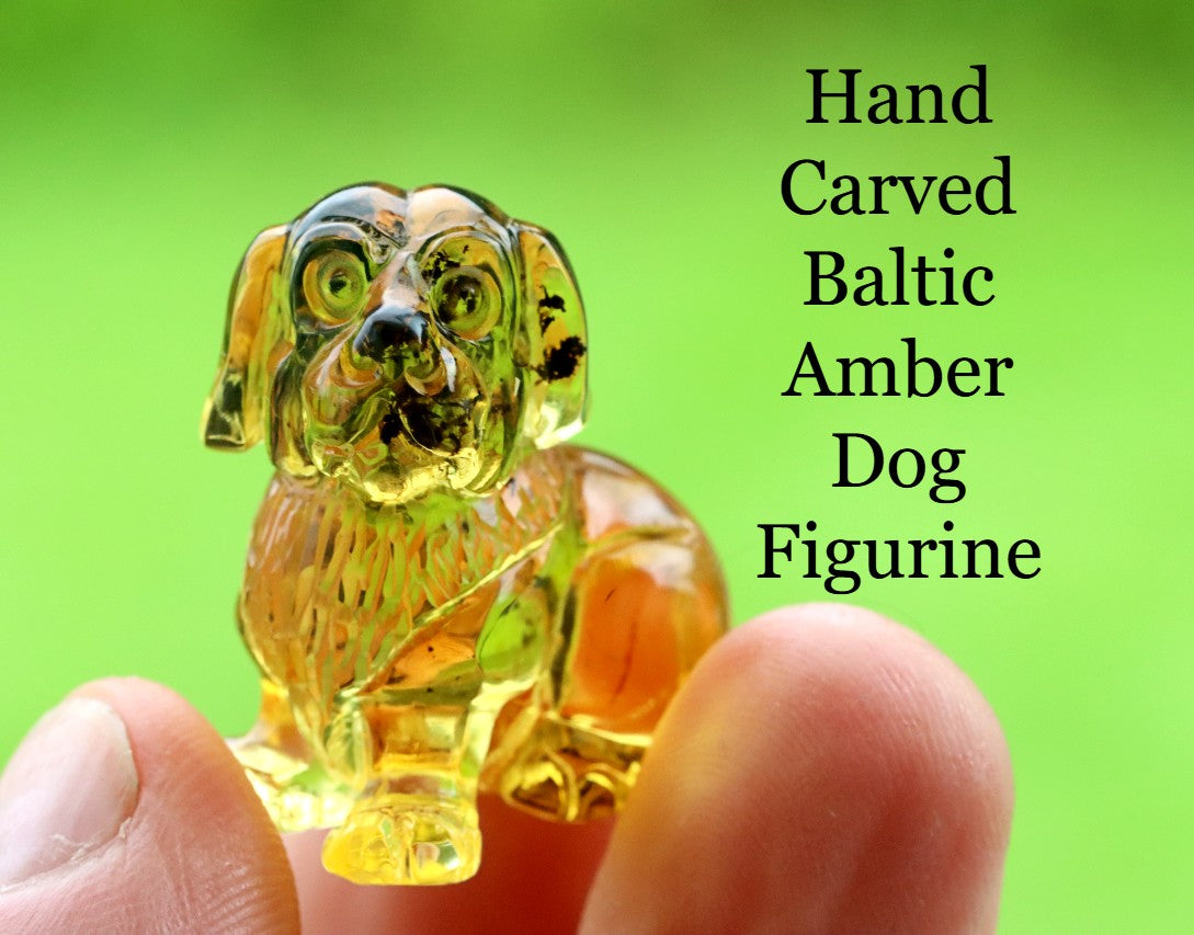 Hand carved Baltic Amber Dog Figurine held between fingers with green background