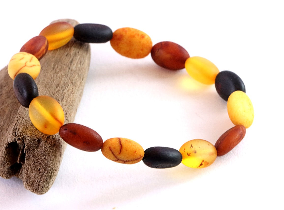 Beaded bracelet with amber and black beads on a white background