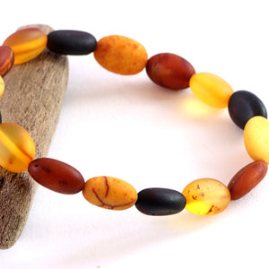 Beaded bracelet with amber and black beads on a white background