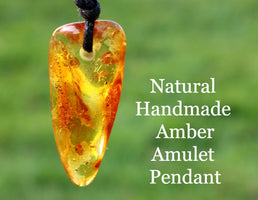 An amber amulet pendant with a rectangular shape, featuring a warm orange color, suspended from a black wax cord.