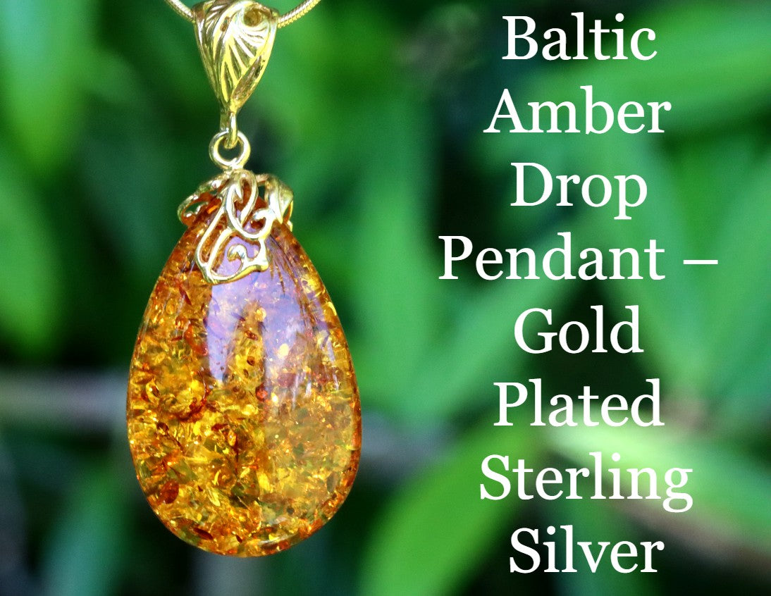 Baltic Amber Drop Pendant with gold plating and sterling silver on a green leaf background