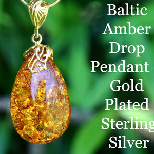 Baltic Amber Drop Pendant with gold plating and sterling silver on a green leaf background