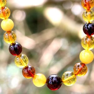 Necklace with multicolored beads against a blurred natural background