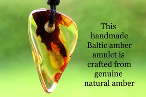 Handmade Baltic amber amulet with text on a green background
