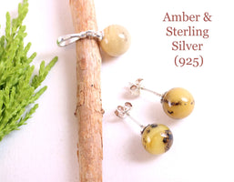 Amber and sterling silver jewelry set on a white background with text indicating material and purity.