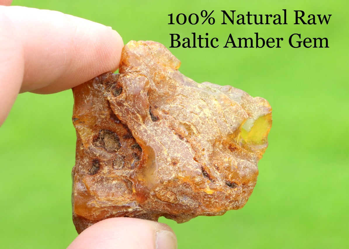 Raw Baltic Amber gem held between fingers with green background and text overlay