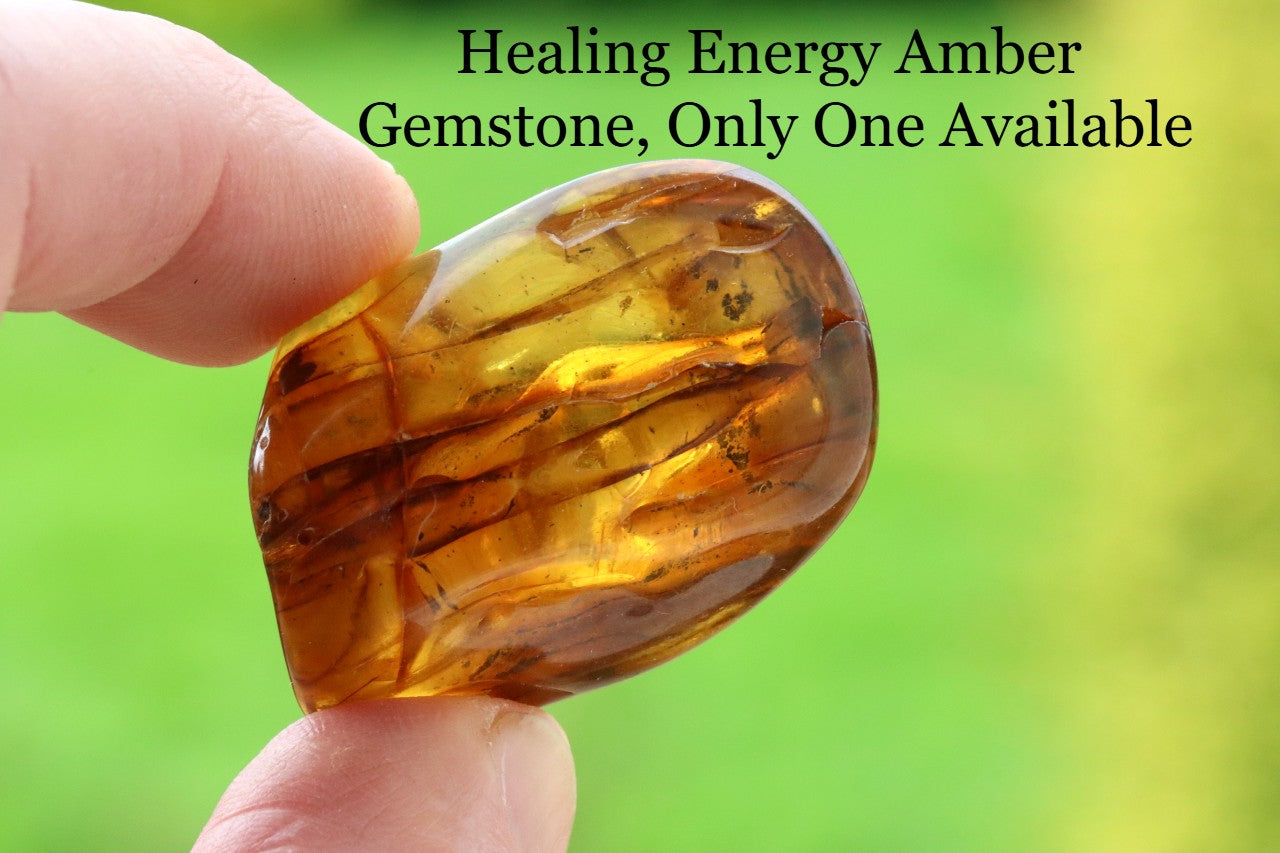 Hand holding a smooth rubbing meditation  gemstone with text overlay on a blurred green background