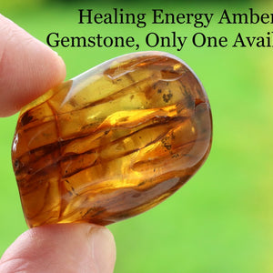 Hand holding a smooth rubbing meditation  gemstone with text overlay on a blurred green background