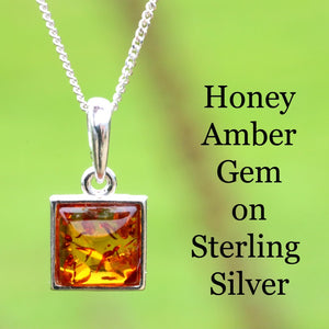 Honey amber gemstone pendant on a silver chain against a green background with text.