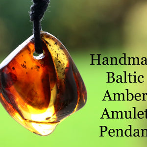 Handmade Baltic Amber Amulet Pendant on a blurred green background