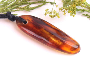 Amber pendant on a white background with greenery