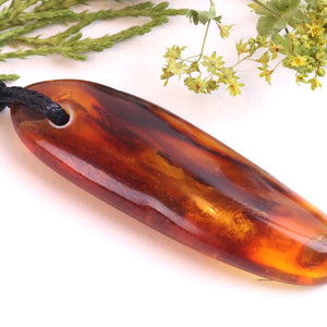 Amber pendant on a white background with greenery
