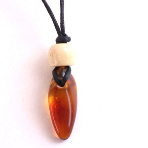 A close-up of a pendant necklace featuring a polished amber-brown teardrop-shaped bead on a black cord, with a small cream-colored spacer bead above it, set against a plain white background.