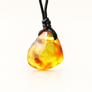A polished amber stone pendant with natural inclusions, suspended from a black cord, shown against a clean white background.