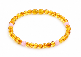A beaded bracelet made of translucent amber-yellow round beads with a few light pink accent beads, photographed on a clean white background.