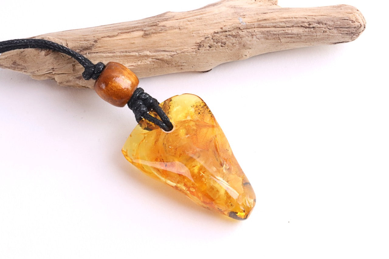 A unique Baltic amber amulet pendant featuring a fascinating insect inclusion