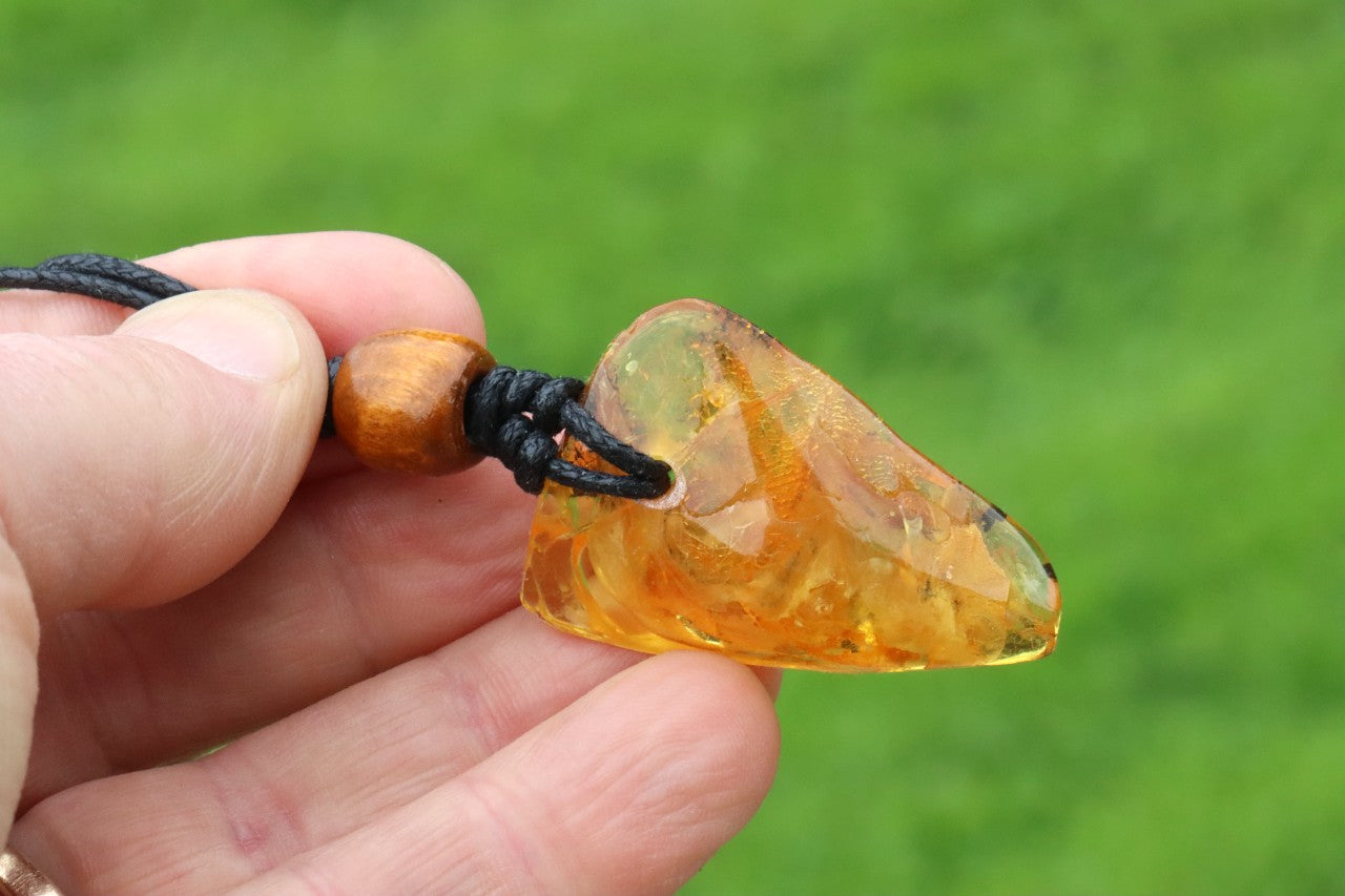 A unique Baltic amber amulet pendant featuring a fascinating insect inclusion