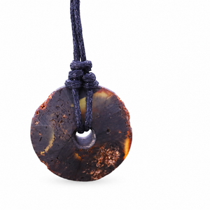 A round circle pendant necklace on a dark cord, isolated on a white background.