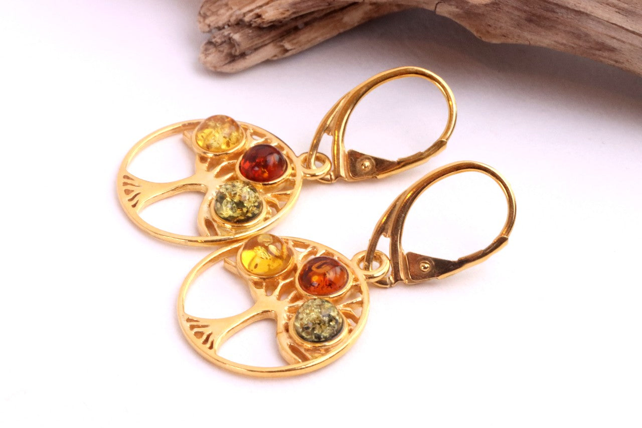 Gold earrings with embedded amber stones on a white background